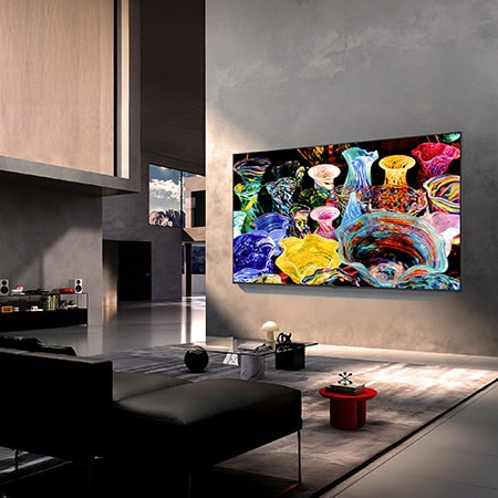 LG Mini RGB evo AI MRGB85 is wall-mounted in a spacious, contemporary living space, displaying a vivid abstract artwork with swirling, multicolored elements.